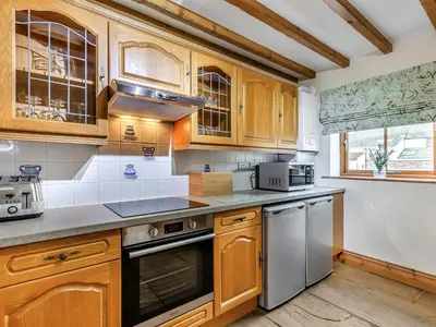 a kitchen with wooden cabinets and stainless steel appliances at Barley Store - Uk48910 in Allonby