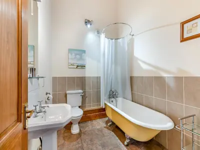a bathroom with a tub and a toilet and a sink at Engine House - Uk48912 in Allonby