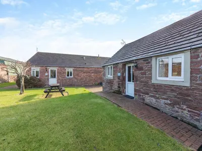 a brick house with a picnic table in the yard at Eight Byre - Uk48913 in Allonby