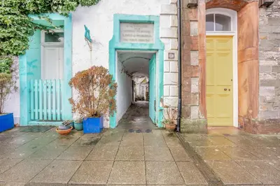 a building with blue and yellow doors and plants at 2 Bed in Kirkcudbright oc-a30803 in Kirkcudbright