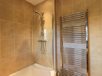 a bathroom with a shower and a tub at Fox Howe in Keswick