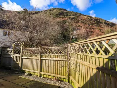 a yellow fence with a mountain in the background at Fox Howe in Keswick