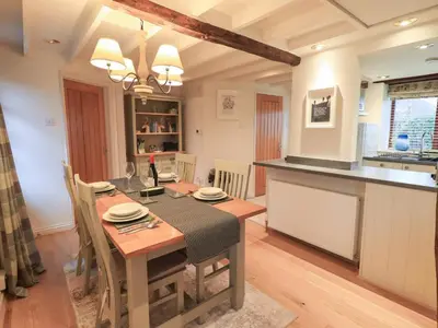 a kitchen and dining room with a table and a counter at Jasmine Cottage in Keswick