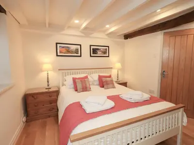 a bedroom with a bed with two towels on it at Jasmine Cottage in Keswick