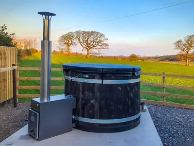 a large trash can sitting next to a fence at Meadows View Shepherd's Hut in Cockermouth