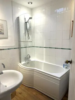 a white bathroom with a tub and a sink at Rose cottage on the peaceful solway coast in Port Carlisle