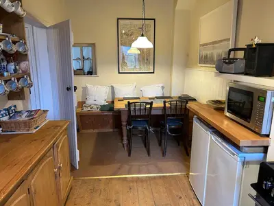 a kitchen with a table with chairs and a microwave at Rose cottage on the peaceful solway coast in Port Carlisle