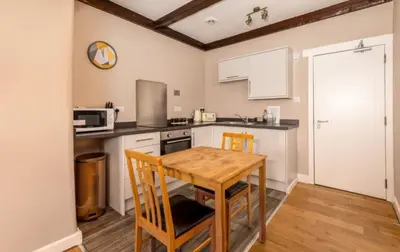 a kitchen with a wooden table and chairs in it at King George IV Inn in Eskdale