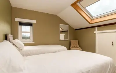 a bedroom with two beds and a skylight at King George IV Inn in Eskdale