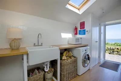a kitchen with a sink and a washing machine at Meadow Cottage in Girthon