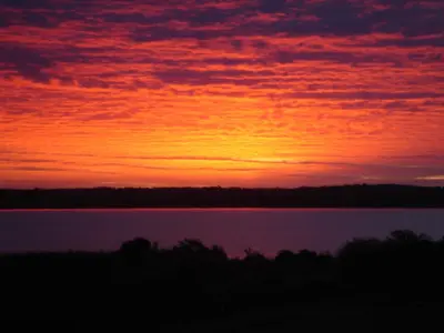 a sunset over a body of water at Muir Lodge in Gatehouse of Fleet