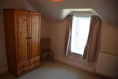 a room with a wooden cabinet and a window at Munro Cottage in Rockcliffe