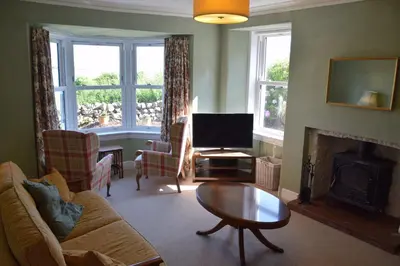 a living room with a couch and a fireplace at Munro Cottage in Rockcliffe
