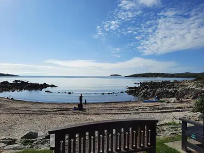 a person standing on a beach near the water at Munro Cottage in Rockcliffe