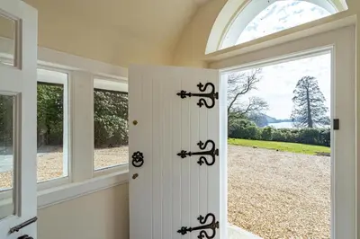 a white door in a room with windows at Ornockenoch House in Gatehouse of Fleet