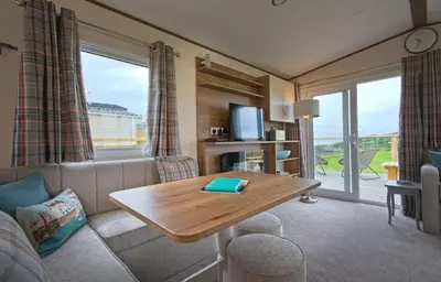 a living room with a couch and a table at Pebbles in Girthon