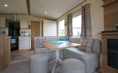 a living room with a couch and a table at Pebbles in Girthon