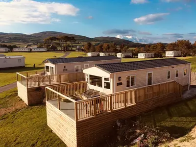 a modular home with a wrap around deck at Pebbles in Girthon