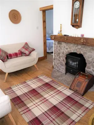 a living room with a couch and a fireplace at Primrose Cottage in Rockcliffe
