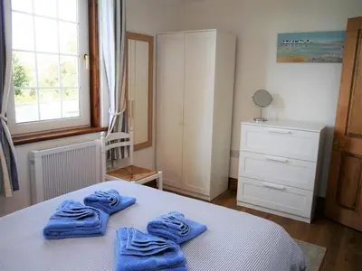 two blue towels on a bed in a bedroom at Primrose Cottage in Rockcliffe