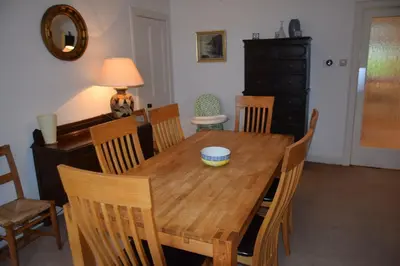 a dining room with a wooden table and chairs at Rocklea in Kippford