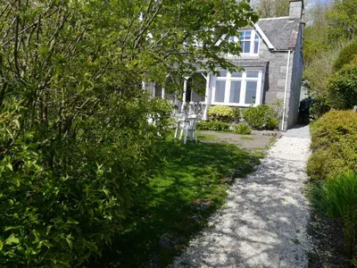 a house with chairs in front of it at Rocklea in Kippford