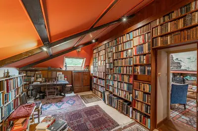 a library with a lot of books on the walls at The Mill in Castle Douglas