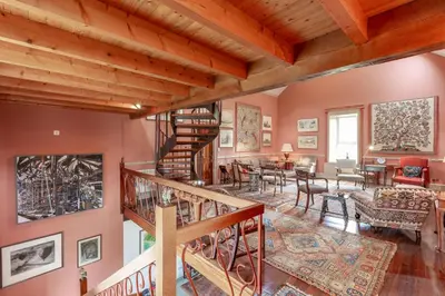 a living room with wooden ceilings and a spiral staircase at The Mill in Castle Douglas