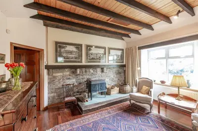 a living room with a stone fireplace and a couch at The Mill in Castle Douglas