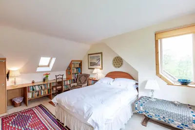 a bedroom with a bed and a window at The Miller's House in Castle Douglas