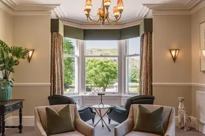 a living room with chairs and a large window at Leathes Head Country House in Keswick