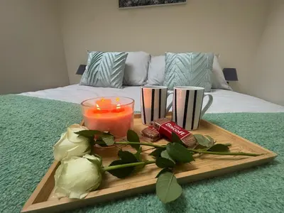 a tray with a candle and two cups on a bed at Hicks Central - Sleeps 2 in Whitehaven