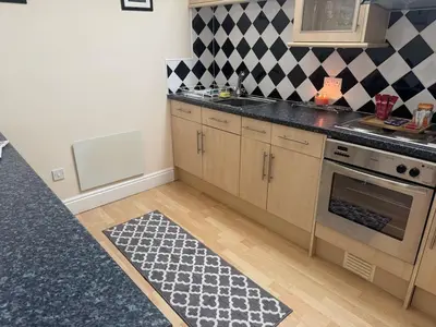 a kitchen with a black and white checkered wall at Hicks Central - Sleeps 2 in Whitehaven