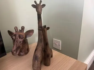 two wooden giraffe statues sitting on top of a table at Hicks Central - Sleeps 2 in Whitehaven