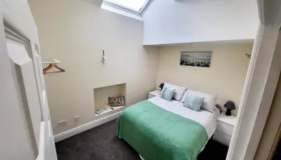a bedroom with a bed with a green blanket at Hicks Central - Sleeps 2 in Whitehaven