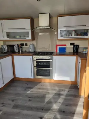 a kitchen with white cabinets and a stove top oven at B&R 18 Gleneagles in Turnberry
