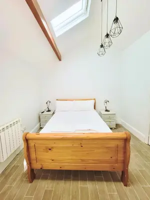 a bedroom with a wooden bed in a room at Kings House in Douglas