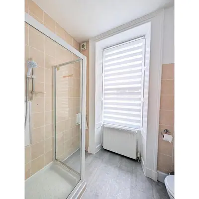 a bathroom with a shower and a glass shower door at Kings House in Douglas