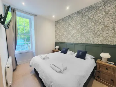 a bedroom with a large white bed with blue pillows at Kings House in Douglas