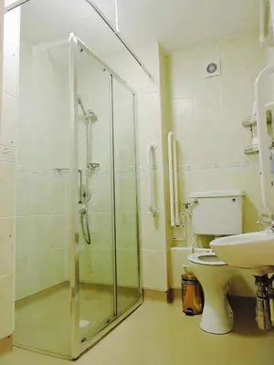 a bathroom with a shower and a toilet and a sink at Fairlight Guesthouse in Glenridding