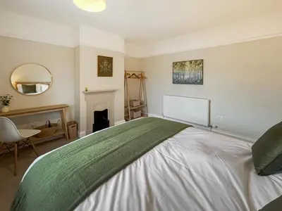 a bedroom with a large bed and a fireplace at Hindsgarth in Keswick