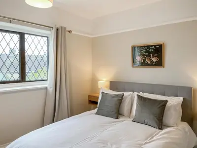 a bedroom with a white bed with a window at Hindsgarth in Keswick