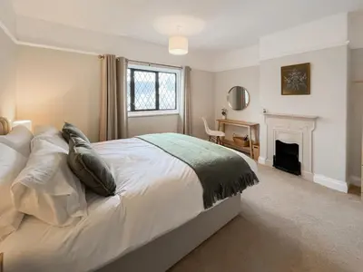 a bedroom with a bed with a fireplace and a desk at Hindsgarth in Keswick