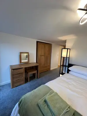 a bedroom with a bed and a dresser with a mirror at Oystercatcher in Dalby