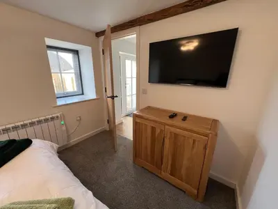 a bedroom with a bed and a flat screen tv on the wall at Oystercatcher in Dalby