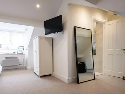 a bedroom with a mirror and a tv on the wall at Skyfell House in Keswick