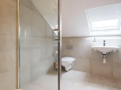a bathroom with a shower and a toilet and a sink at Skyfell House in Keswick
