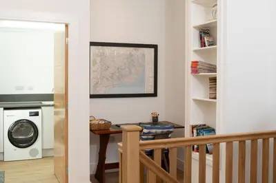 a laundry room with a table and a washer and dryer at 2 Kippford Slipway in Kippford