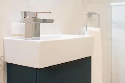 a bathroom with a white sink in a bathroom at 2 Kippford Slipway in Kippford