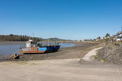 a boat sitting on the shore of a beach at 2 Kippford Slipway in Kippford